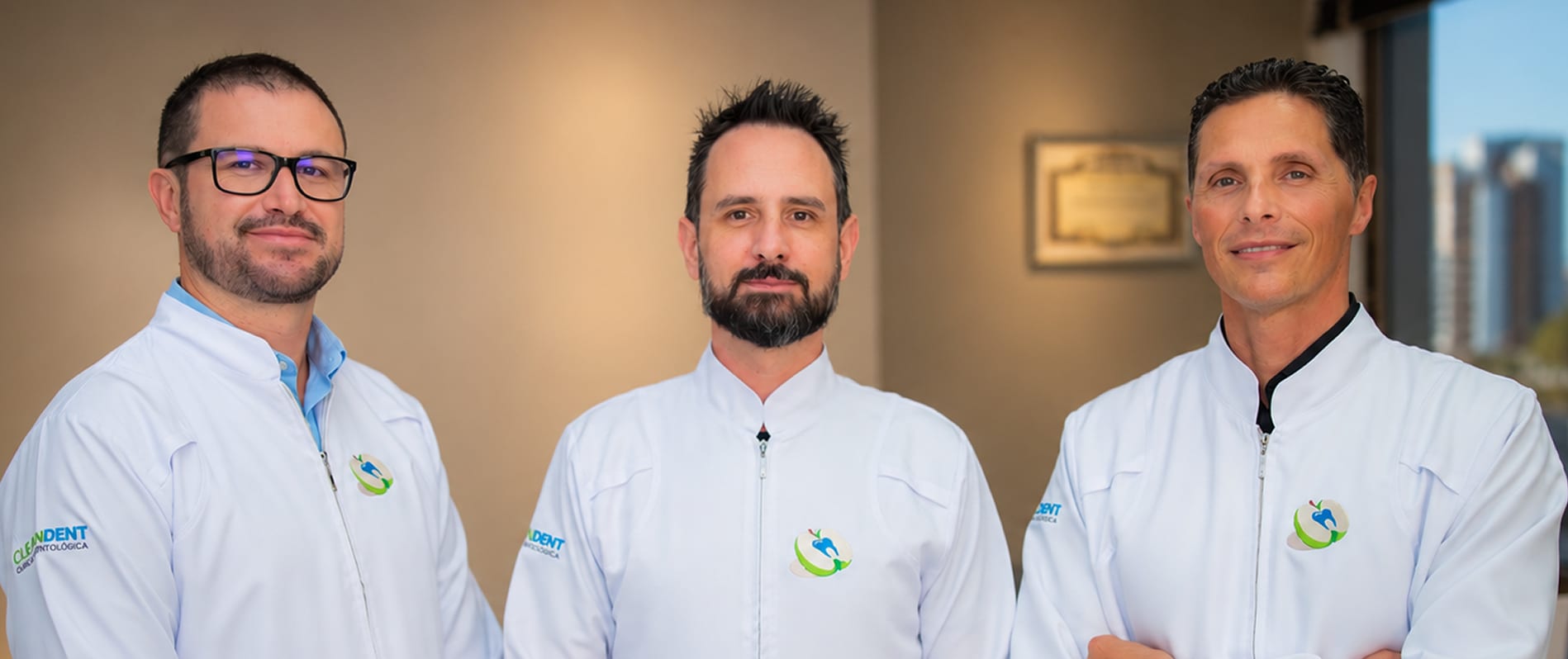 Três dentistas da CleanDent de jaleco branco